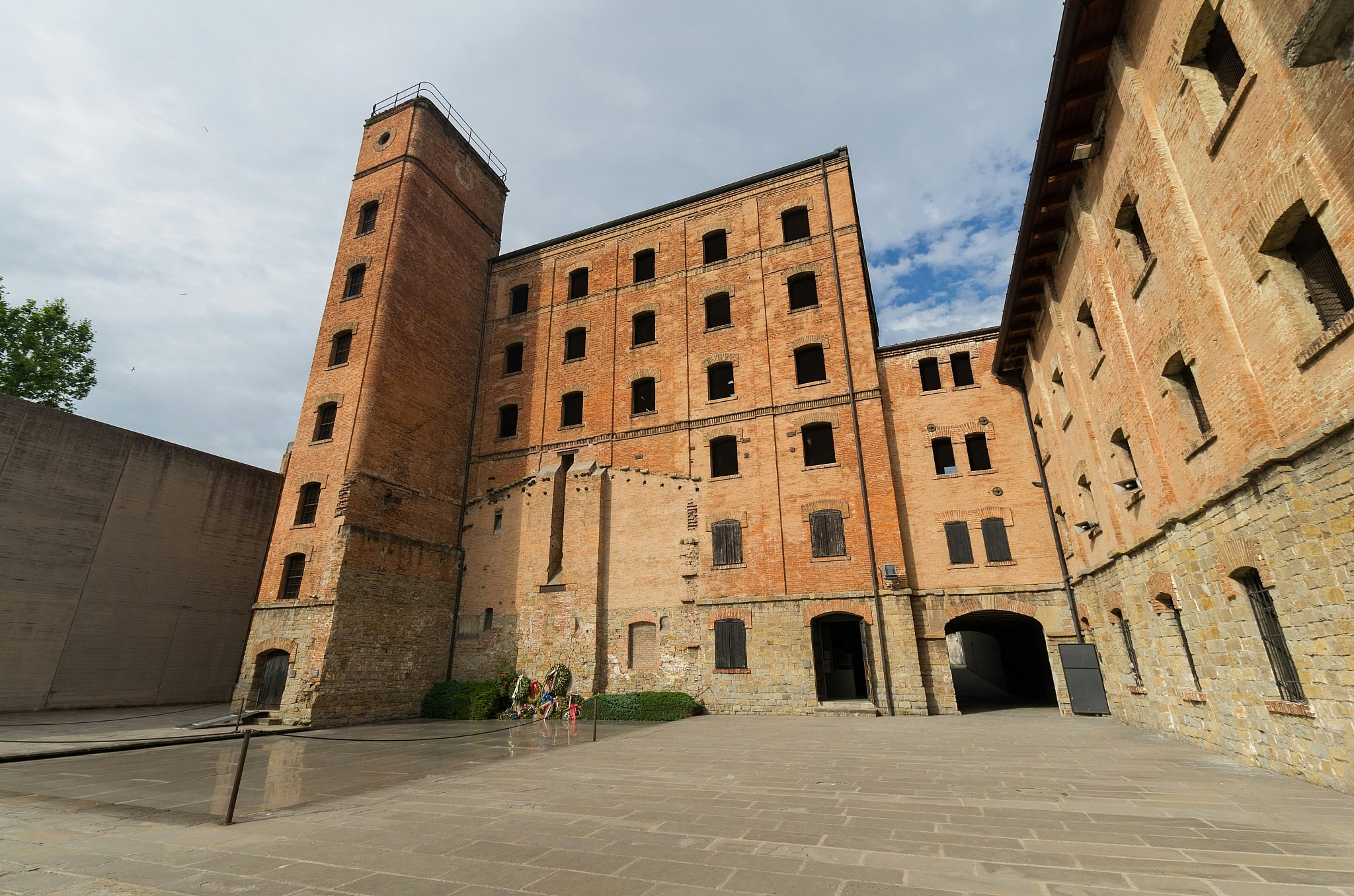 An internal courtyard partly surrounded by the six-storey redbrick building of a former rice mill.